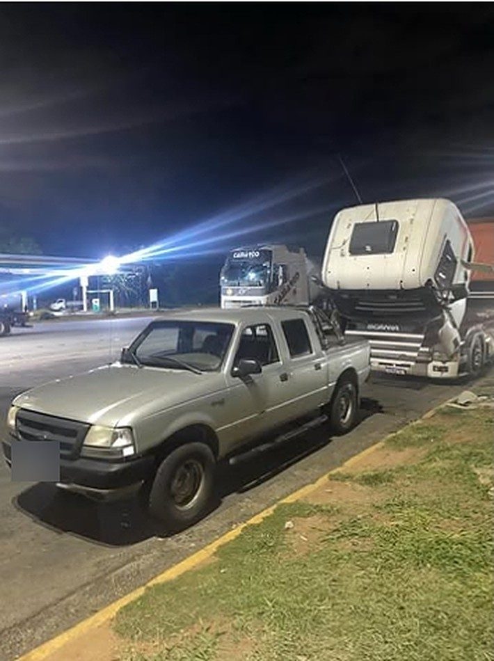 Príncipe do Socorro, socorro e mecânica móvel em Campinas: pickup Ford Ranger e caminhão Scania com a cabine levantada, à noite, em um posto de estrada
